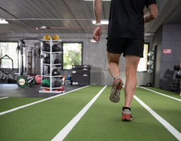 indoor run track, strength training, run coaching for athletes, athletic training in Melbourne, Melbourne run coaching, strength coach Melbourne, man running in indoor track