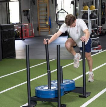 private athletics coaching, male athlete pushing sled, strength training for athletes, private strength coaching for athletes Melbourne, strength training Melbourne
